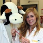 Biotechnologiestudentin Anna Wronska und Team-Maskottchen Kuh Carola.
