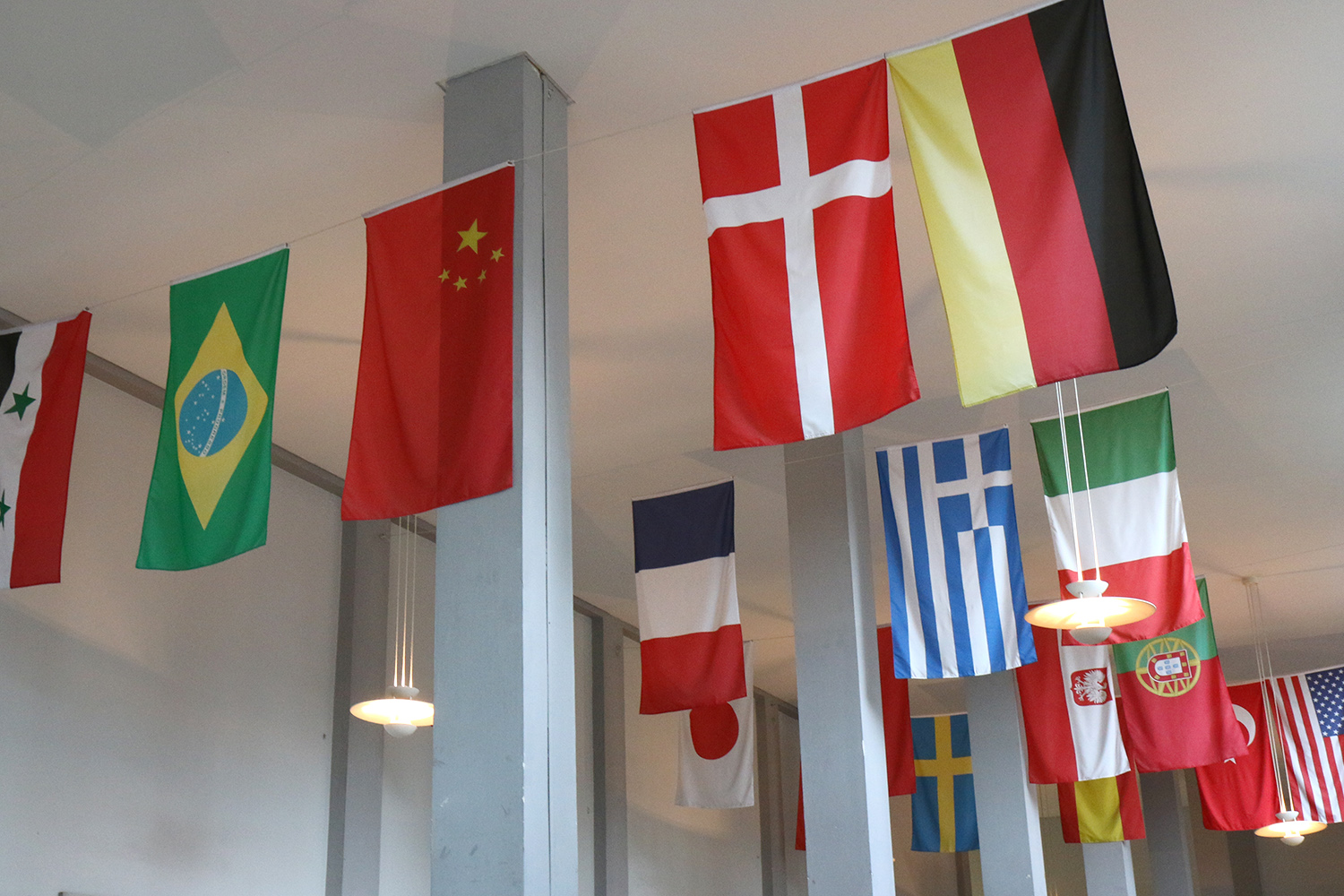 Internationale Flaggen hängen in den Arkaden des Altgebäudes.