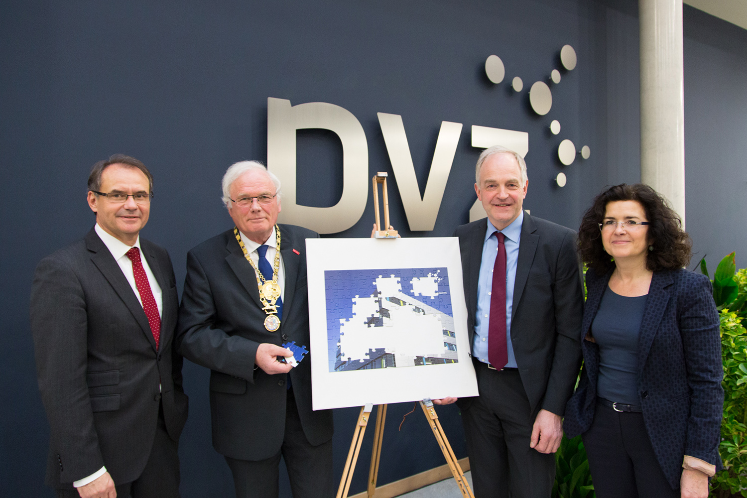 Das Bild zeigt die vier Personen vor einer Staffelei mit einem Puzzle des PVZ. Einige Puzzlestücke fehlen noch, eines davon hält der TU-Braunschweig Präsident.