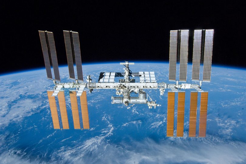 Zu sehen ist die Internationale Raumstation ISS, die über der Erde fliegt.