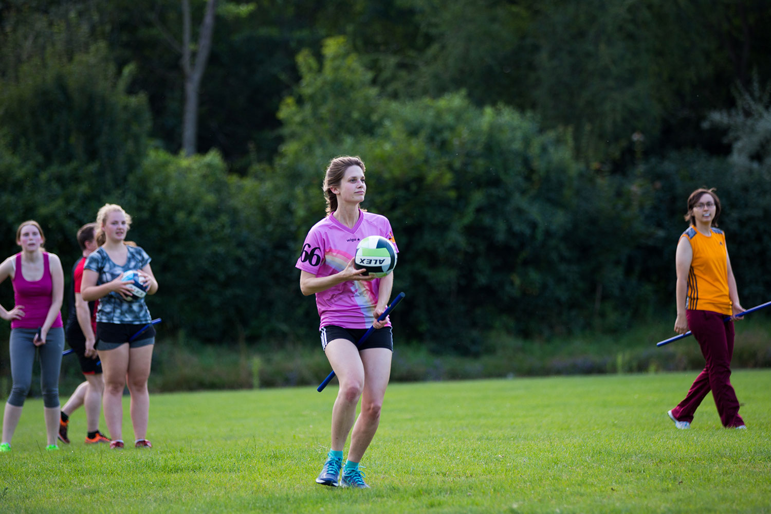 Zu sehen ist eine Quidditchspielerin mit Besen und Ball in der Hand.