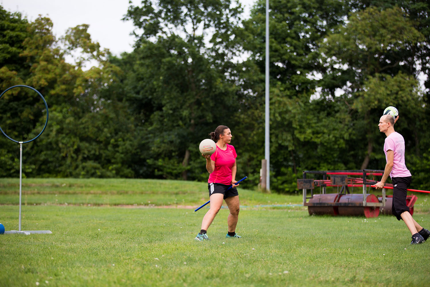 Zwei Quidditchspieler laufen in einer Spielszene aufeinander zu und werfen die Bälle.