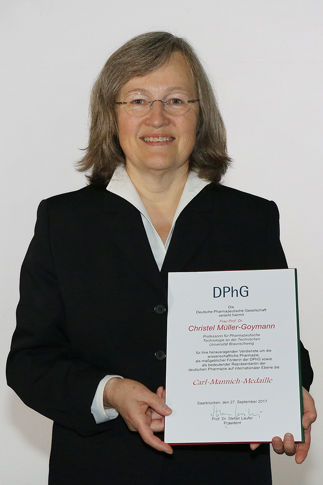 Zu sehen ist Prof. Dr. Christel Müller-Goymann im Porträt. In der Hand hält sie eine Urkunde.
