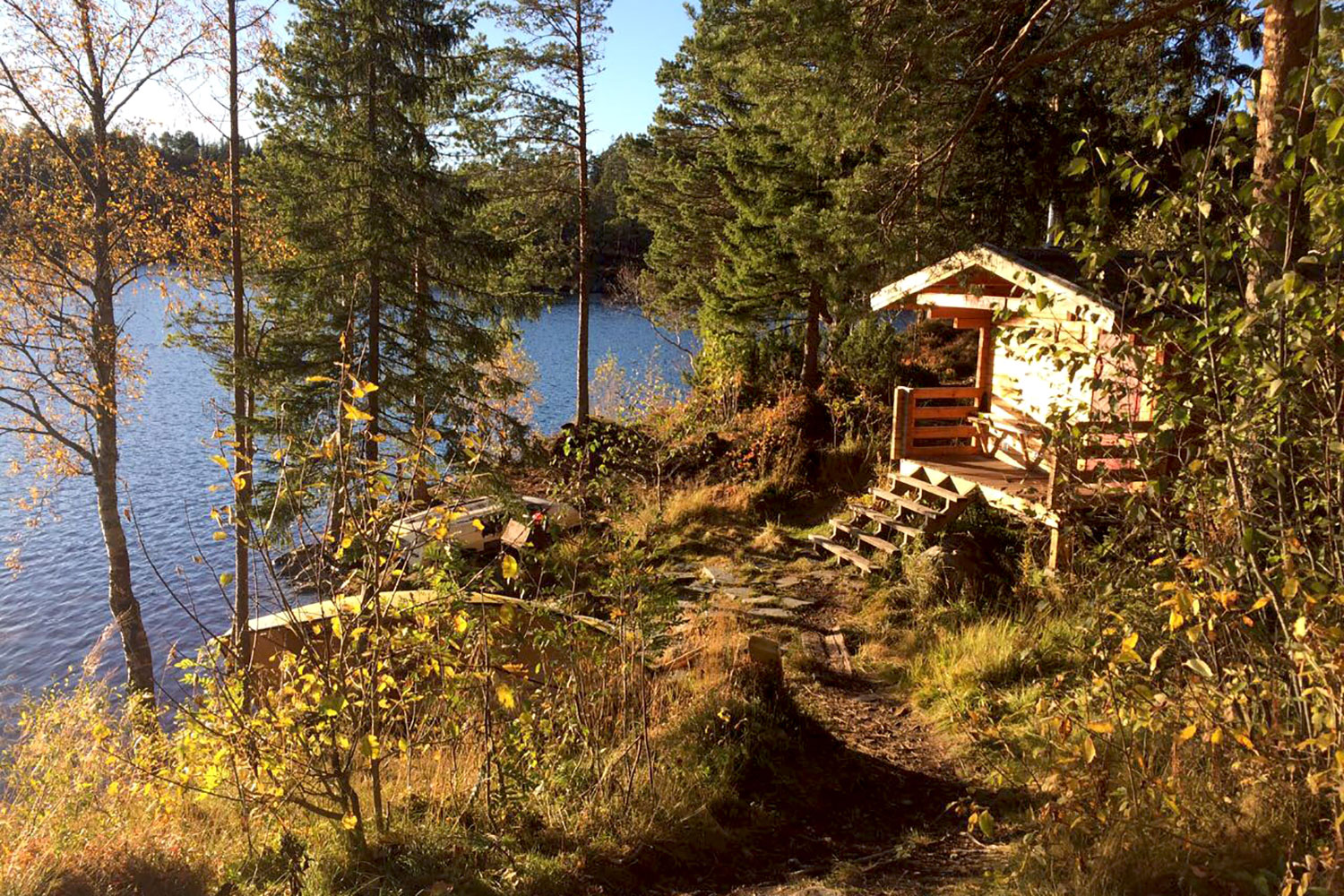 Eine Holzhütte, direkt am Ufer eines Sees gelegen.