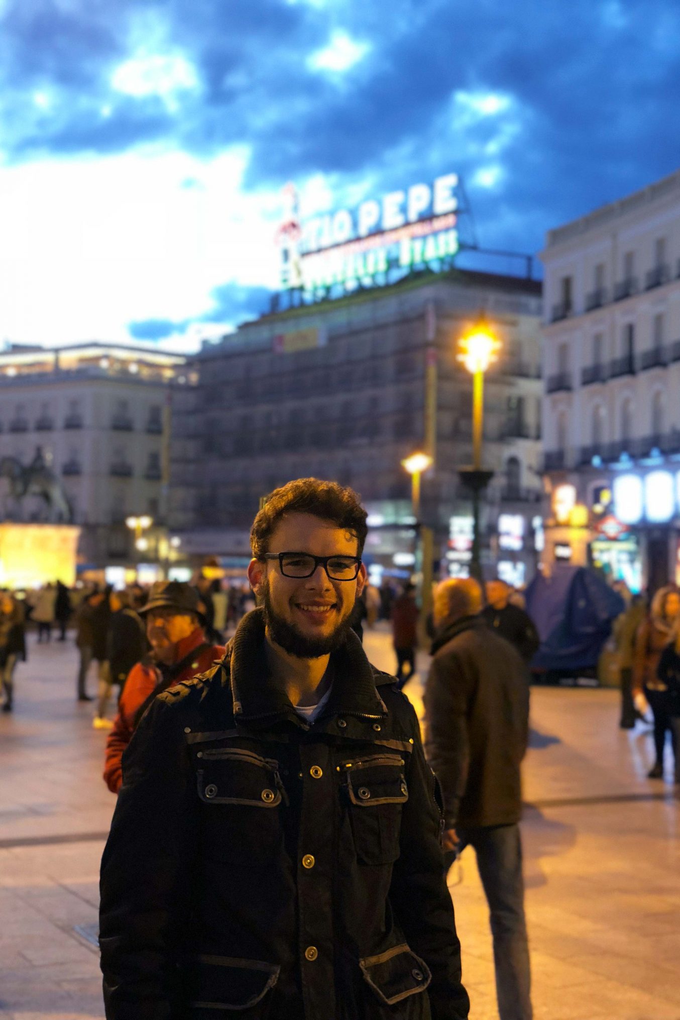 Zu sehen sind der Student und im Hintergrund der Hauptplatz "Puerta del Sol".