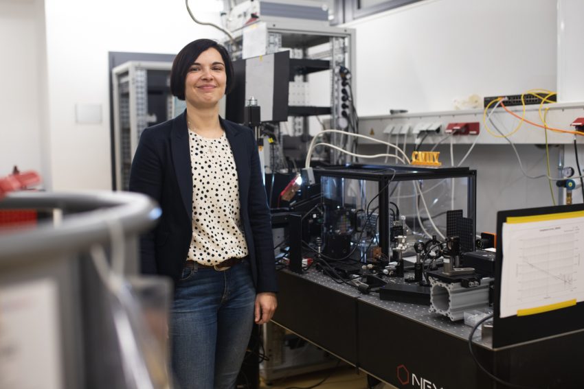 Professorin Stefanie Kroker steht vor ihrem Laboraufbau, an dem sie optische Bauteile für den Quantencomputer des QVLS entwickelt.