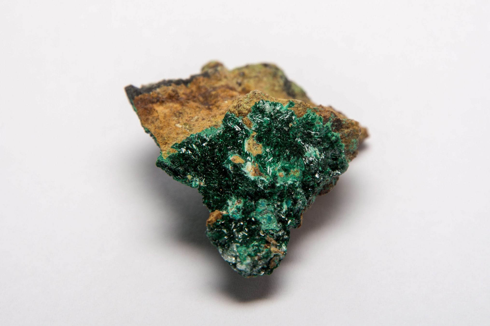 Ein kleiner Stein mit einer dünnen Schicht grüner Atacamit-Kristalle auf der Oberfläche