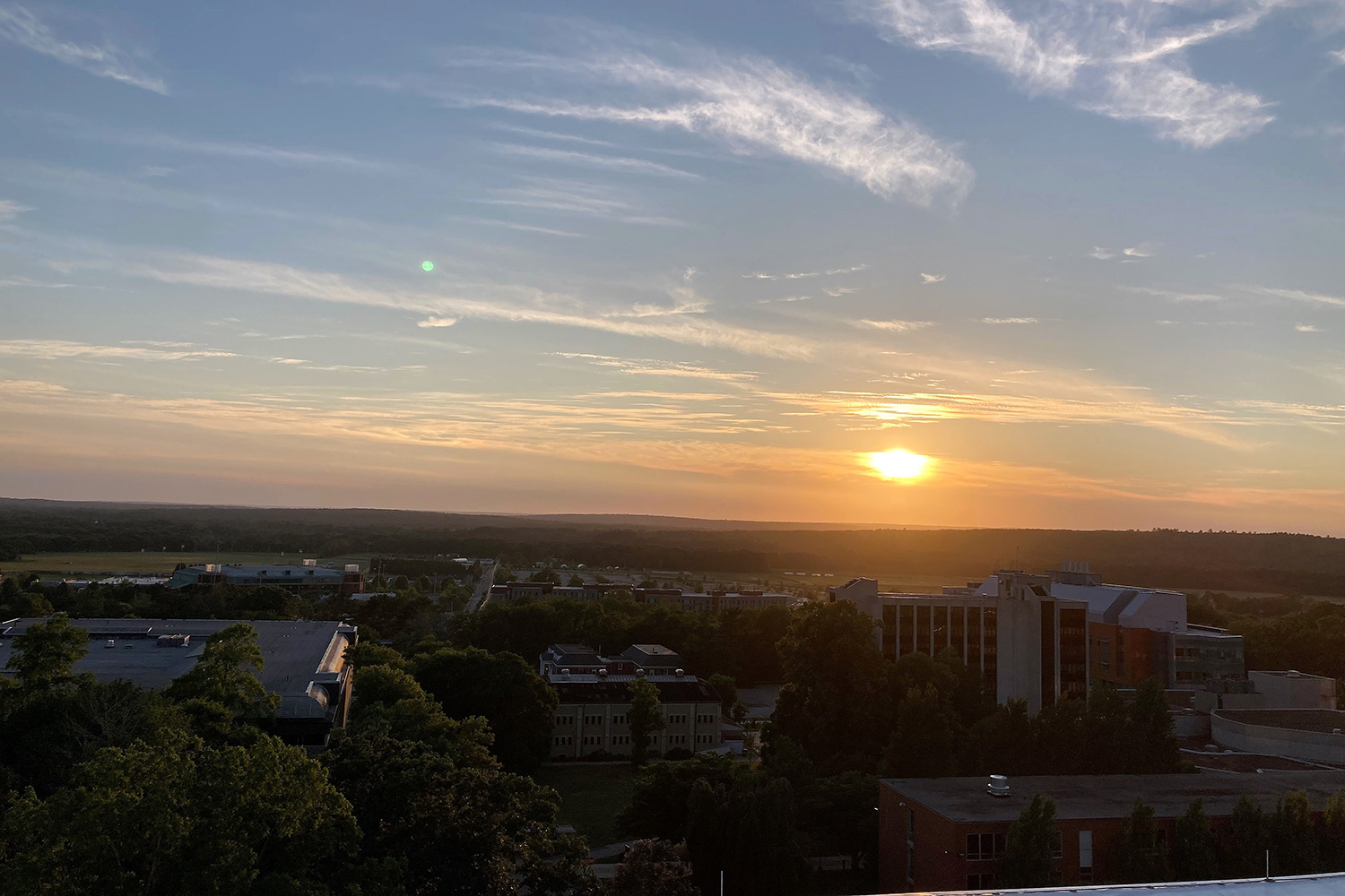 The sun sets over the campus of the University of Rhode Island.