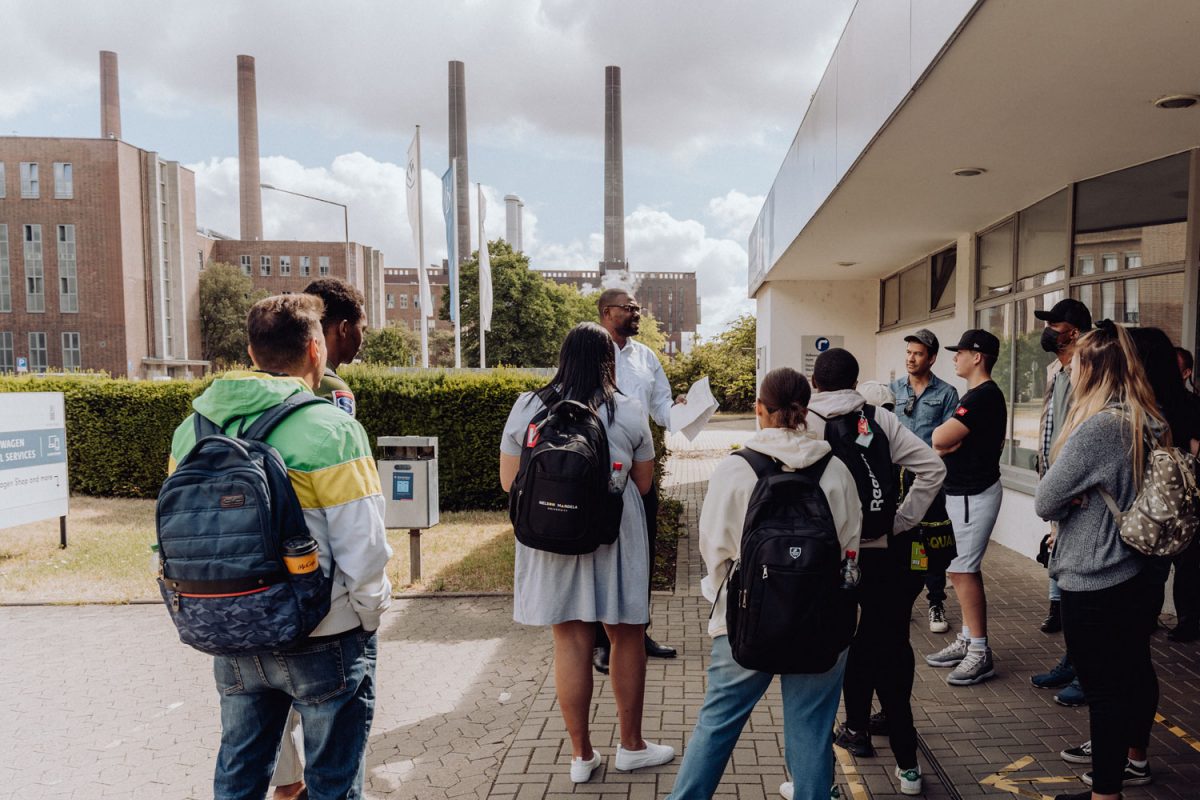 A group of international students talking to a staff member during an excursion to a company.