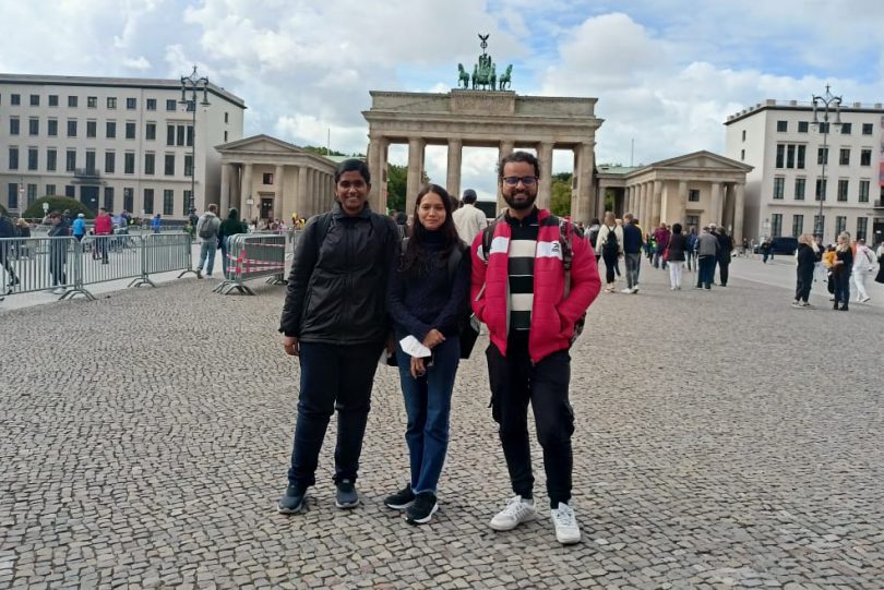 Drei Studierende stehen vor dem Brandenburger Tor in Berlin.